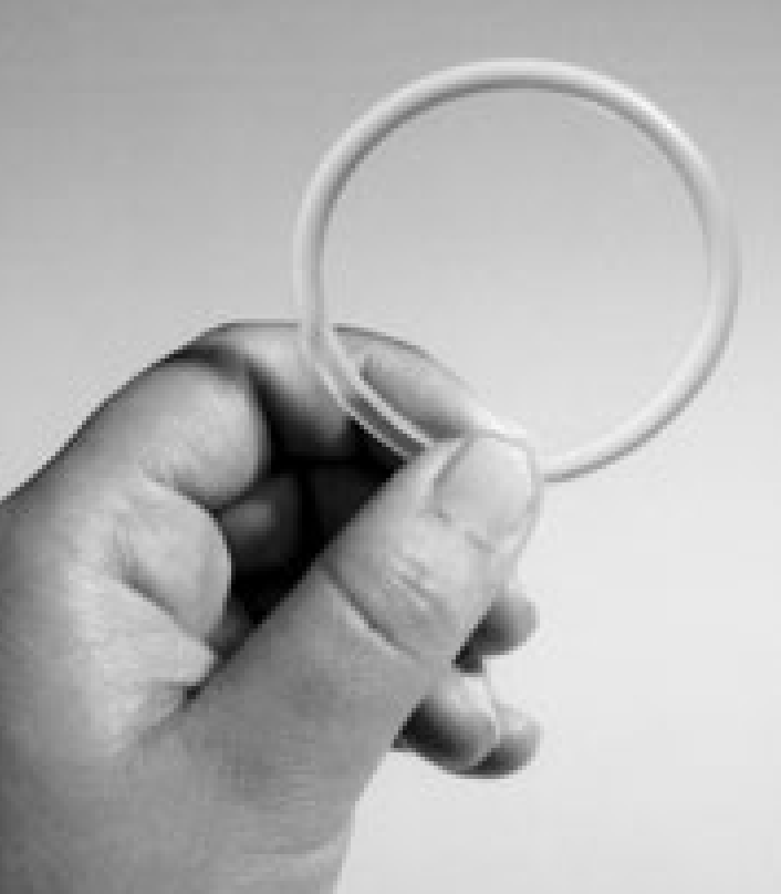 A hand holding up a Combined Vaginal Ring